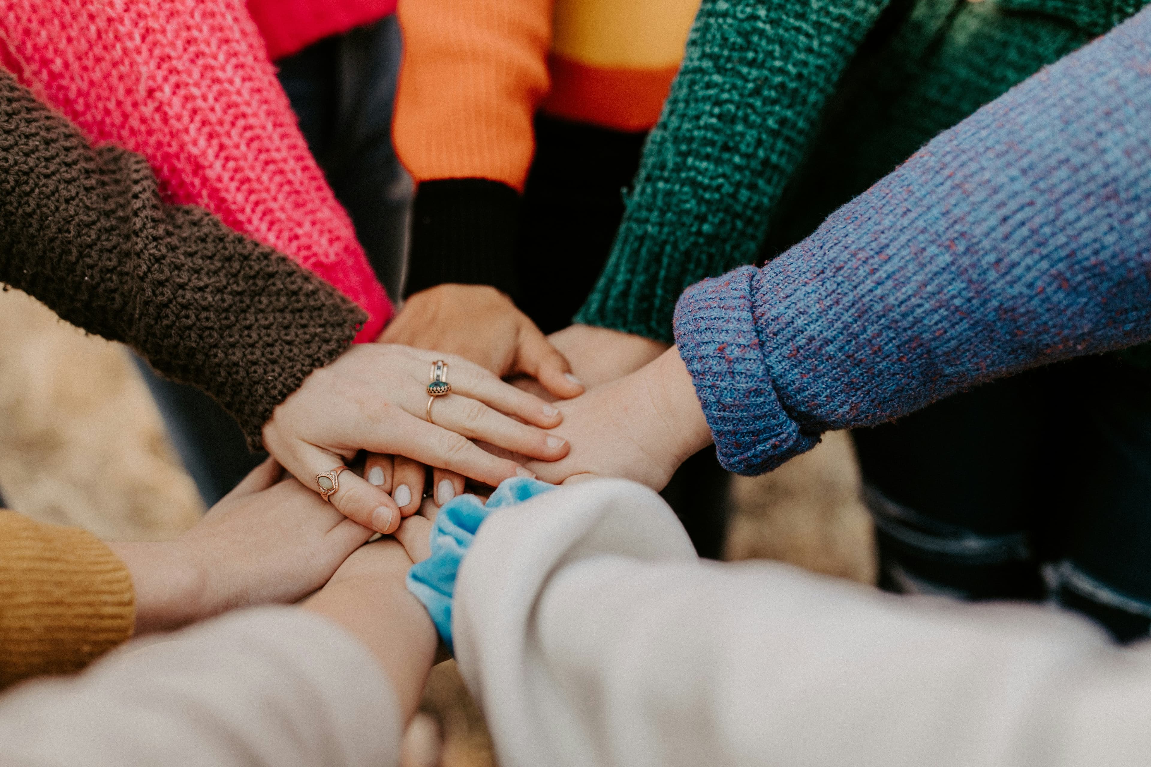 Hands joined together, representing collaborative team-based patient care