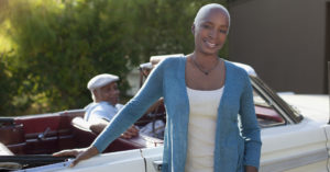 Older woman leaning on convertible